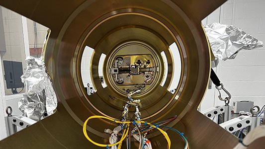 The inside of the tREXS optical bench. At the far end of the tube is the detector shutter door, protecting the cold camera from the telescope tube environment. Harnessing runs along the bottom of the optical bench to control the external shutter door and star-tracker. Then holes in the side of the optical bench allow access for harnessing before the optical bench slides into the external skins.